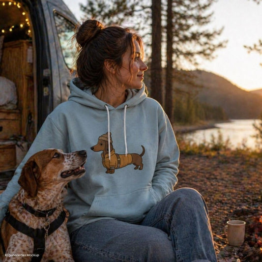 Camping mit Hund Frau im Hoodie mit Dackel Print Vanlife Szene am See Camper Natur Outdoor mit Hund
